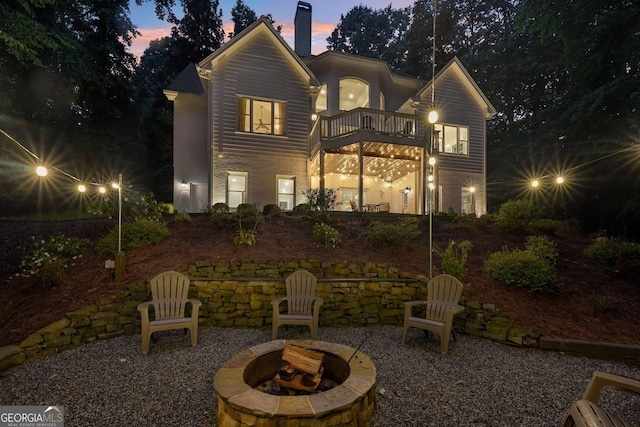 15305 Highgrove Rd, Milton, GA 30004 - back of property at dusk featuring a balcony, an outdoor fire pit, and a chimney