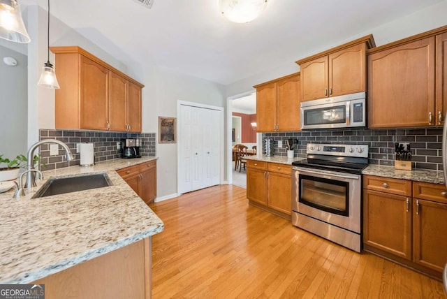 9320 Old Preserve Trl, Ball Ground, GA 30107 - kitchen featuring appliances with stainless steel finishes, light stone counters, tasteful backsplash, and light wood finished floors
