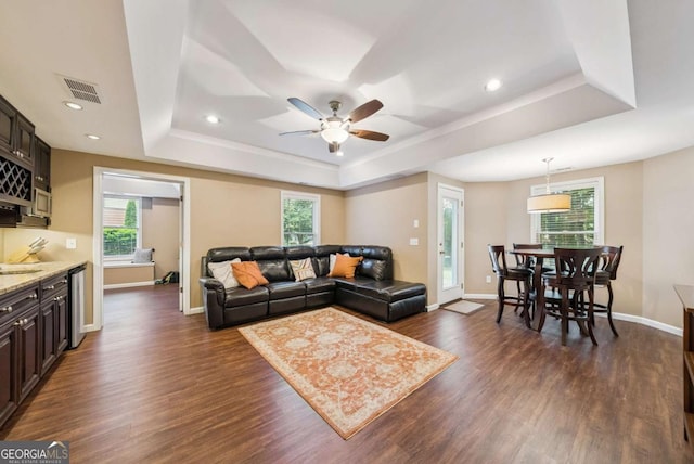 9320 Old Preserve Trl, Ball Ground, GA 30107 - living room featuring a raised ceiling, healthy amount of natural light, dark wood finished floors, ceiling fan, and recessed lighting