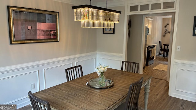 3066 Gem Creek Rd, Buford, GA 30519 - dining space featuring a decorative wall, dark wood-style flooring, crown molding, wainscoting, and a chandelier