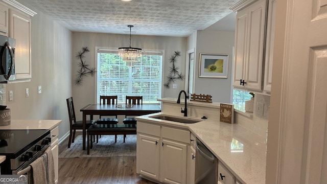 3066 Gem Creek Rd, Buford, GA 30519 - kitchen with stainless steel appliances, a chandelier, dark wood-style flooring, a peninsula, and pendant lighting