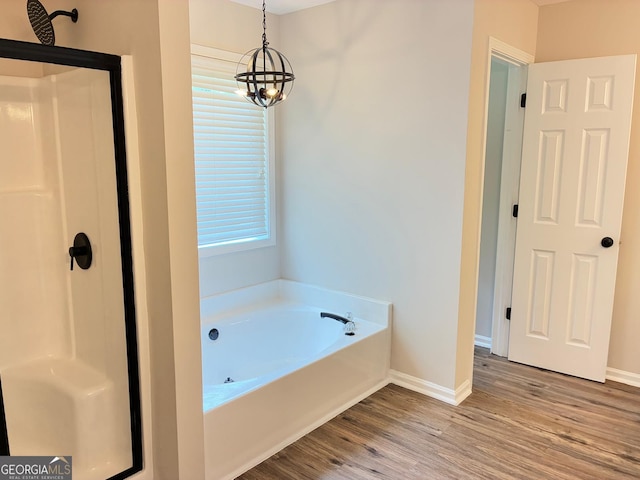 3066 Gem Creek Rd, Buford, GA 30519 - bathroom with wood finished floors, a shower stall, a bath, and a chandelier
