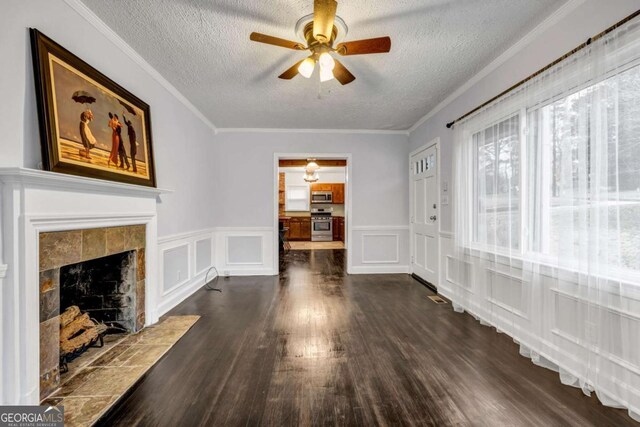 1747 Parkhill Dr, Decatur, GA 30032 - unfurnished living room with ceiling fan, a textured ceiling, a decorative wall, dark wood-style floors, and a tile fireplace
