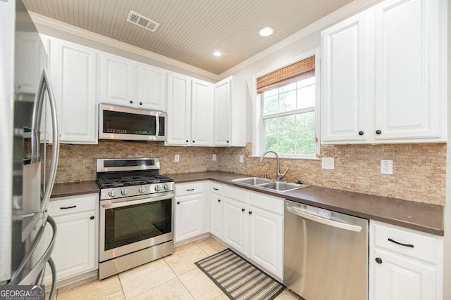 2427 Camata Pl, Marietta, GA 30066 - kitchen featuring appliances with stainless steel finishes, dark countertops, crown molding, light tile patterned flooring, and white cabinets