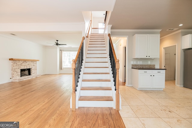 2427 Camata Pl, Marietta, GA 30066 - stairway with crown molding, ceiling fan, a fireplace, recessed lighting, and wood finished floors