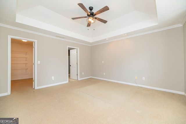2427 Camata Pl, Marietta, GA 30066 - unfurnished bedroom featuring a tray ceiling, light colored carpet, ornamental molding, a walk in closet, and ceiling fan