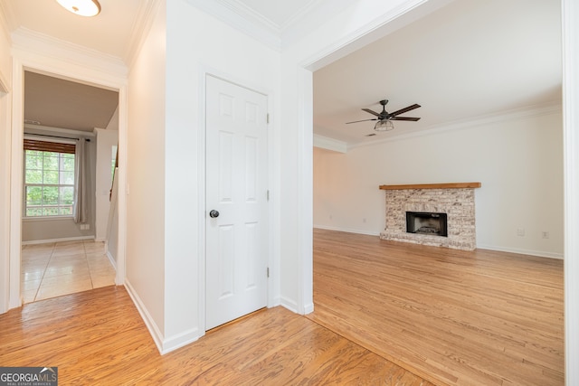 2427 Camata Pl, Marietta, GA 30066 - unfurnished living room with light wood-style flooring, ornamental molding, a ceiling fan, and a fireplace