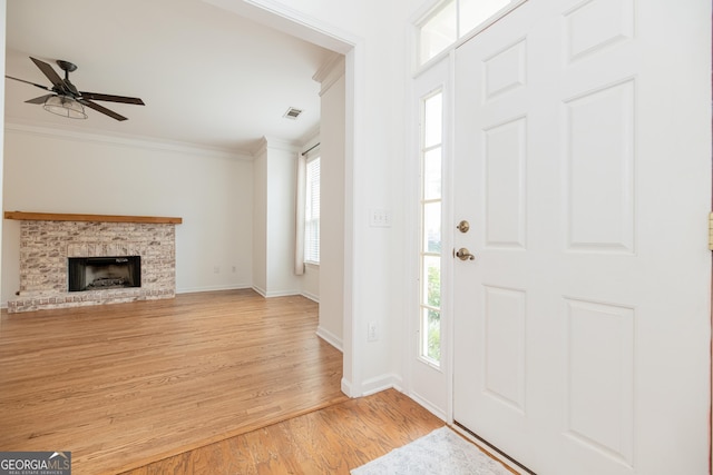 2427 Camata Pl, Marietta, GA 30066 - foyer featuring ornamental molding, light wood-style floors, ceiling fan, and a brick fireplace