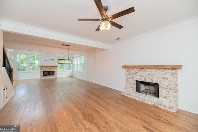 2427 Camata Pl, Marietta, GA 30066 - unfurnished living room featuring a brick fireplace, ornamental molding, a ceiling fan, and light wood-style floors