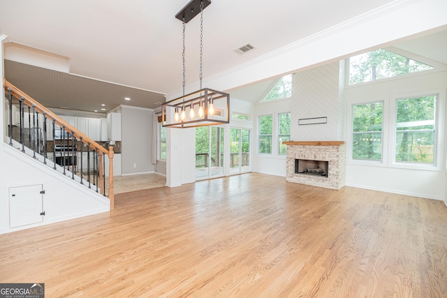2427 Camata Pl, Marietta, GA 30066 - unfurnished living room featuring light wood-style floors, a fireplace, stairs, crown molding, and a chandelier
