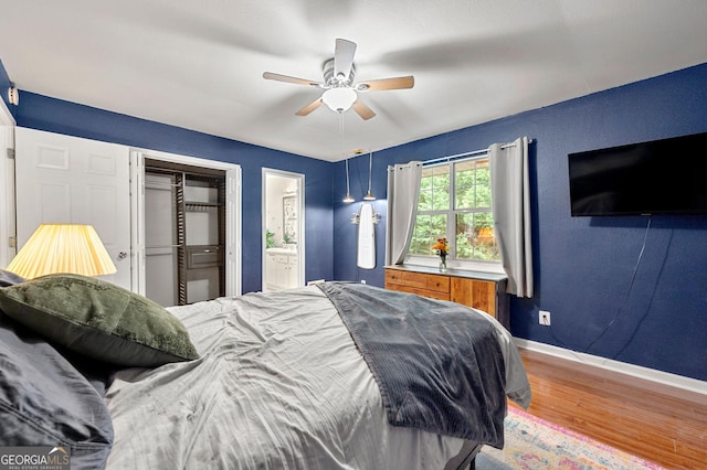 3149 Buford Hwy NE, Atlanta, GA 30329 - bedroom featuring wood finished floors, connected bathroom, a ceiling fan, and a closet