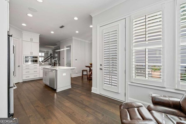 18 Peachtree Ave NE Unit 5, Atlanta, GA 30305 - kitchen with crown molding, stainless steel appliances, dark wood-style floors, open floor plan, and white cabinetry