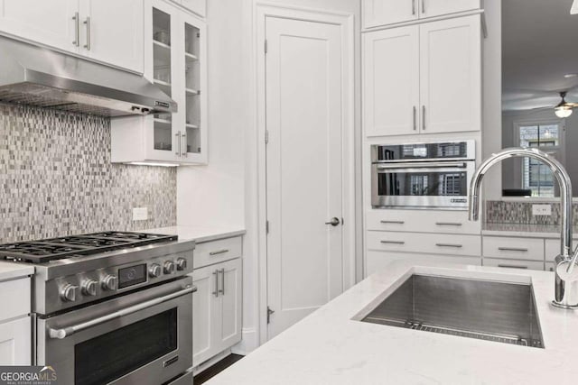 18 Peachtree Ave NE Unit 5, Atlanta, GA 30305 - kitchen featuring stainless steel appliances, under cabinet range hood, backsplash, white cabinetry, and light stone countertops