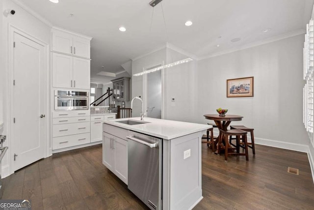 18 Peachtree Ave NE Unit 5, Atlanta, GA 30305 - kitchen with appliances with stainless steel finishes, dark wood-style flooring, a center island with sink, ornamental molding, and light countertops