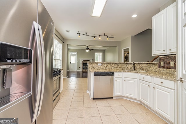 24 Arendt Park Ln, Newnan, GA 30263 - kitchen with stainless steel appliances, a peninsula, light tile patterned floors, and white cabinets