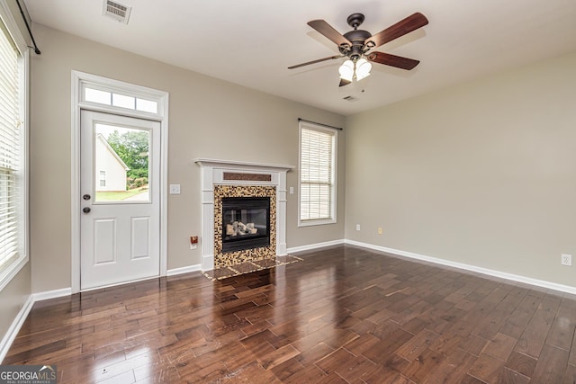 24 Arendt Park Ln, Newnan, GA 30263 - unfurnished living room featuring dark wood-type flooring, a ceiling fan, healthy amount of natural light, and a tiled fireplace