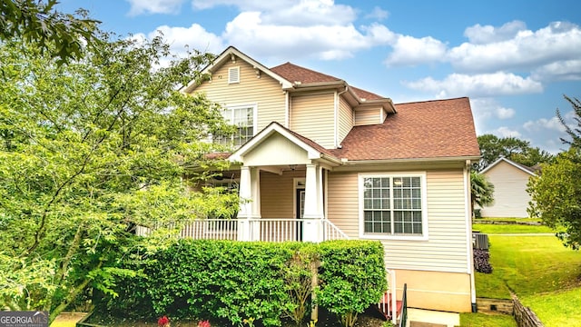 24 Arendt Park Ln, Newnan, GA 30263 - traditional home featuring a front yard, roof with shingles, a porch, and a ceiling fan