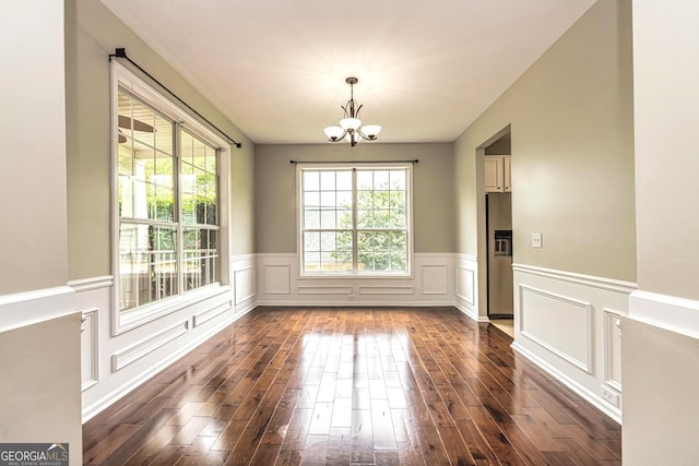 24 Arendt Park Ln, Newnan, GA 30263 - unfurnished dining area with a chandelier, dark wood-style floors, a wainscoted wall, and a decorative wall