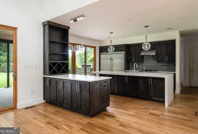 497 Rutherford St, Athens, GA 30606 - kitchen with built in refrigerator, under cabinet range hood, light countertops, open shelves, and light wood-style floors
