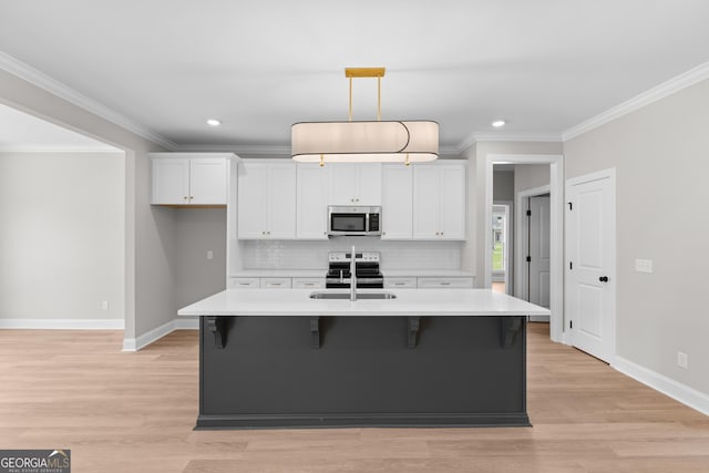 10 Honeysuckle Dr, Claxton, GA 30417 - kitchen with stainless steel appliances, white cabinets, ornamental molding, light countertops, and light wood finished floors