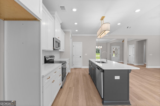 10 Honeysuckle Dr, Claxton, GA 30417 - kitchen featuring appliances with stainless steel finishes, white cabinets, light wood-style floors, light countertops, and a kitchen island with sink