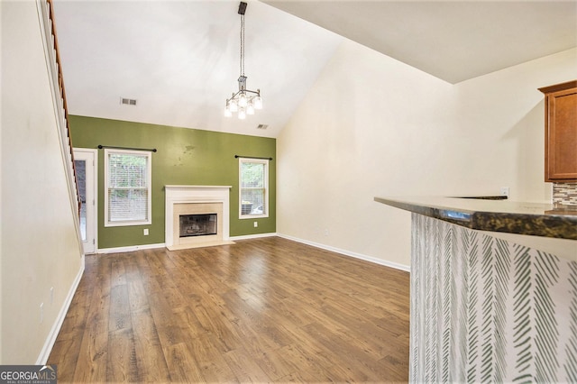 113 Macalester Dr, Newnan, GA 30265 - unfurnished living room with wood finished floors, a premium fireplace, a chandelier, and lofted ceiling