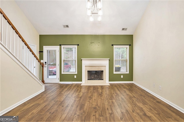 113 Macalester Dr, Newnan, GA 30265 - unfurnished living room featuring plenty of natural light, stairs, wood finished floors, and a chandelier