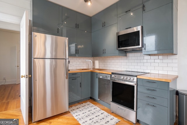 75 Ponce De Leon Ave NE Unit 1004, Atlanta, GA 30308 - kitchen featuring appliances with stainless steel finishes, butcher block counters, light wood finished floors, and backsplash