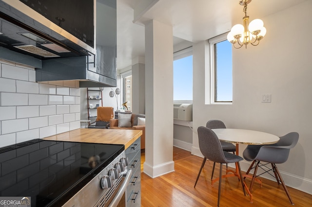 75 Ponce De Leon Ave NE Unit 1004, Atlanta, GA 30308 - kitchen with light wood finished floors, a chandelier, butcher block counters, stainless steel appliances, and tasteful backsplash