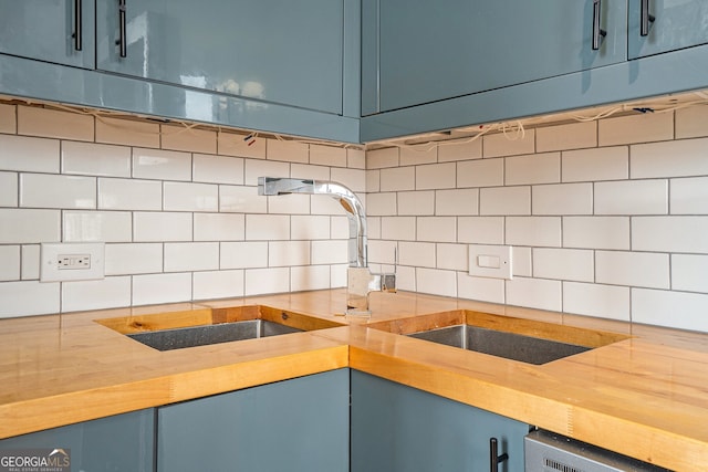 75 Ponce De Leon Ave NE Unit 1004, Atlanta, GA 30308 - kitchen featuring blue cabinets, decorative backsplash, and light countertops