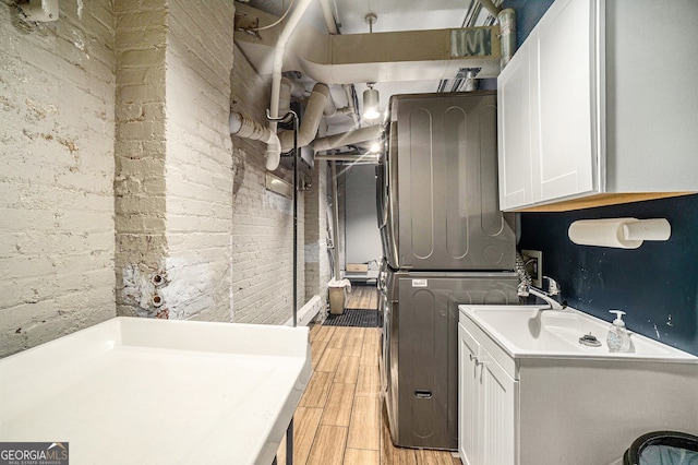 75 Ponce De Leon Ave NE Unit 1004, Atlanta, GA 30308 - laundry area featuring stacked washer / drying machine, cabinet space, and light wood-style flooring