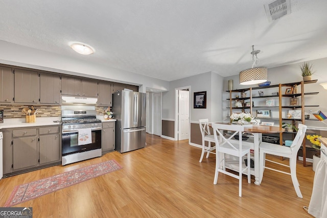 289 Westland Way SW, Marietta, GA 30064 - kitchen with stainless steel appliances, under cabinet range hood, gray cabinetry, light wood-style flooring, and light countertops