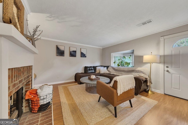 289 Westland Way SW, Marietta, GA 30064 - living area with light wood-style floors, a textured ceiling, ornamental molding, and a brick fireplace
