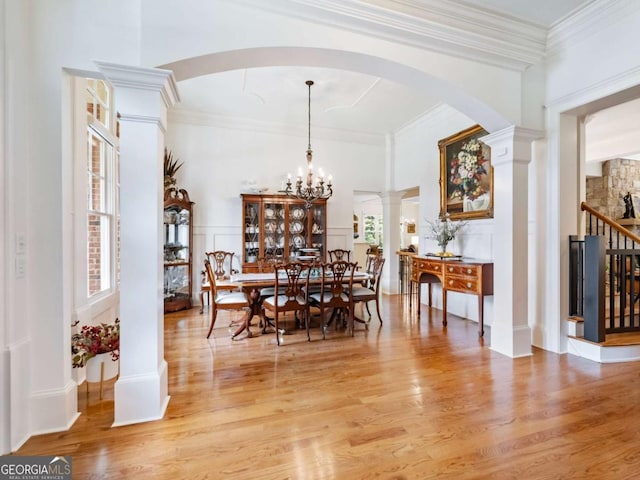 2392 Crimson King Dr, Braselton, GA 30517 - dining space with light wood-type flooring, arched walkways, crown molding, stairway, and a chandelier
