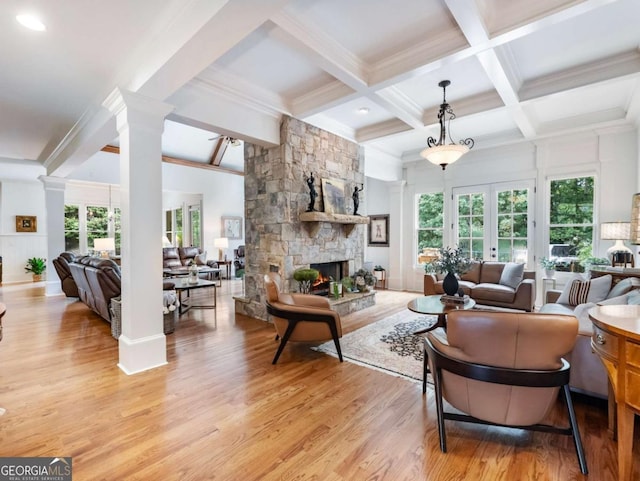 2392 Crimson King Dr, Braselton, GA 30517 - living room featuring beam ceiling, light wood-type flooring, decorative columns, a stone fireplace, and ornamental molding