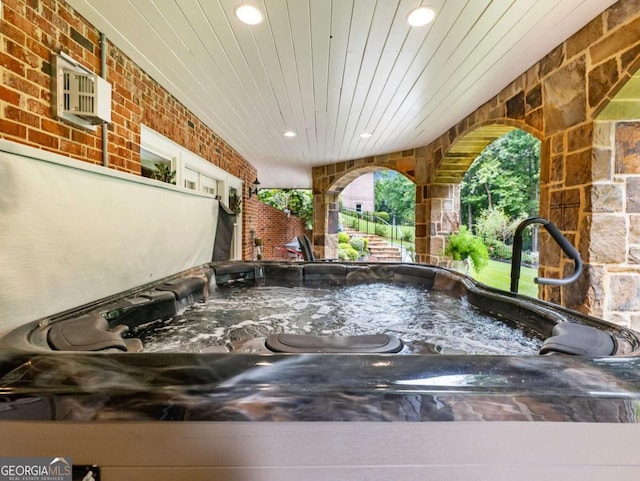 2392 Crimson King Dr, Braselton, GA 30517 - exterior view of a jacuzzi, brick siding, a wall mounted air conditioner, and stone siding