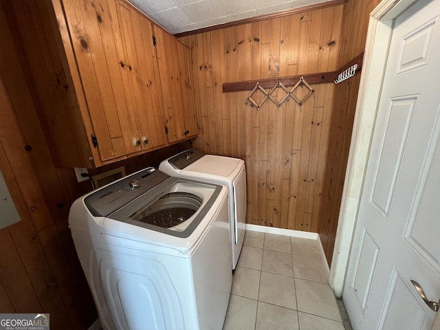 9 Henry St, Statesboro, GA 30458 - washroom featuring separate washer and dryer, wood walls, light tile patterned floors, and cabinet space