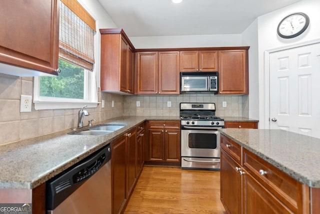 1609 Vinery Ln SE, Mableton, GA 30126 - kitchen with stainless steel appliances, light stone countertops, light wood-style flooring, and decorative backsplash