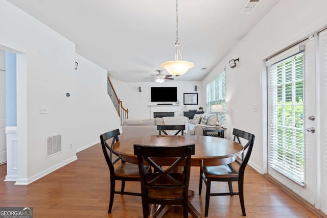 1609 Vinery Ln SE, Mableton, GA 30126 - dining space featuring wood finished floors, a fireplace, and a ceiling fan
