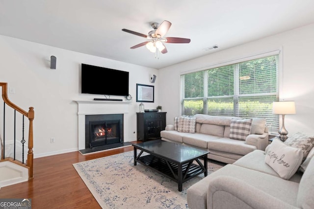 1609 Vinery Ln SE, Mableton, GA 30126 - living area with ceiling fan, stairs, wood finished floors, and a warm lit fireplace