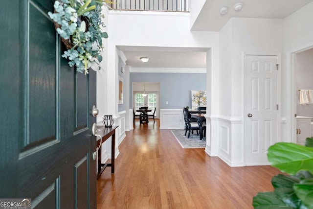 1609 Vinery Ln SE, Mableton, GA 30126 - entryway with light wood finished floors, a wainscoted wall, crown molding, and a decorative wall
