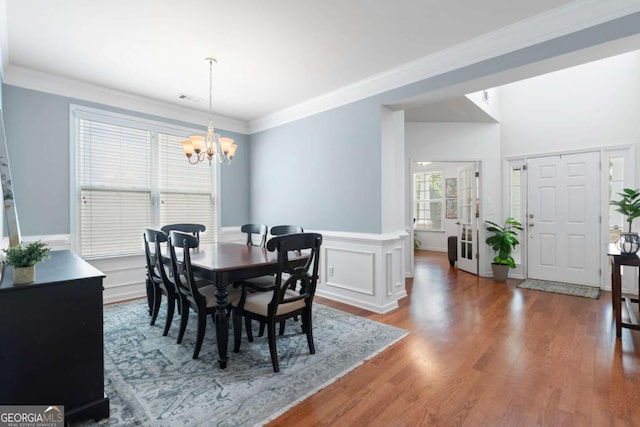1609 Vinery Ln SE, Mableton, GA 30126 - dining area with a chandelier, ornamental molding, wood finished floors, and wainscoting