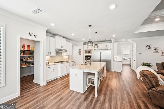 4189 Brookmont Way, Auburn, GA 30011 - kitchen with built in appliances, under cabinet range hood, recessed lighting, a kitchen breakfast bar, and wood finished floors