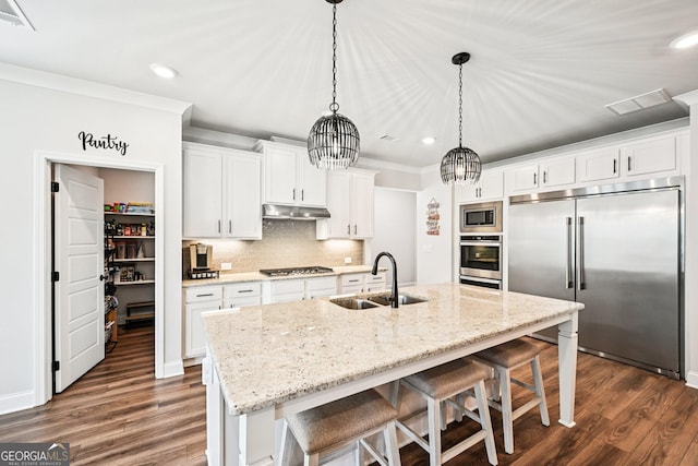 4189 Brookmont Way, Auburn, GA 30011 - kitchen featuring built in appliances, recessed lighting, under cabinet range hood, ornamental molding, and dark wood finished floors