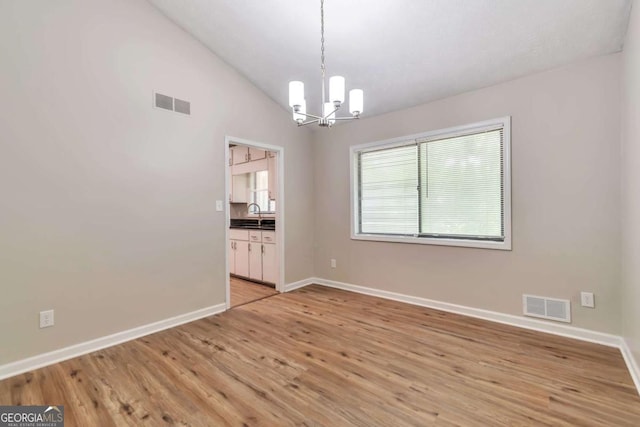 5215 Mainstreet Park Dr, Stone Mountain, GA 30088 - unfurnished dining area featuring a chandelier, light wood-style floors, and vaulted ceiling