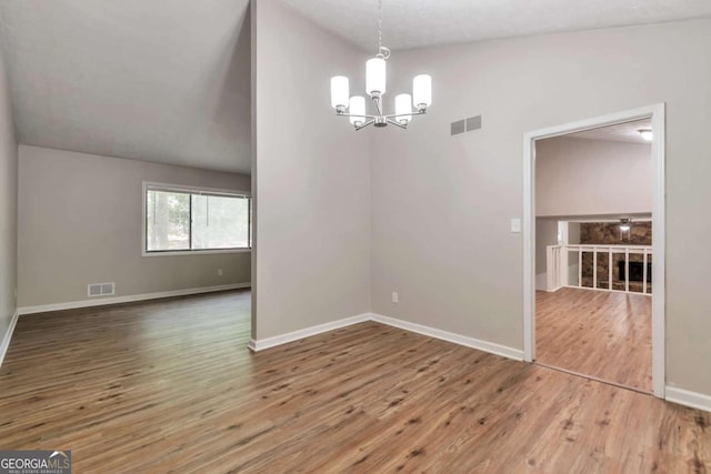 5215 Mainstreet Park Dr, Stone Mountain, GA 30088 - spare room featuring a chandelier, wood finished floors, and vaulted ceiling