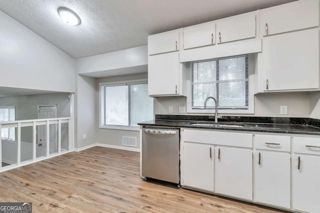 5215 Mainstreet Park Dr, Stone Mountain, GA 30088 - kitchen featuring stainless steel dishwasher, white cabinets, light wood finished floors, a textured ceiling, and healthy amount of natural light
