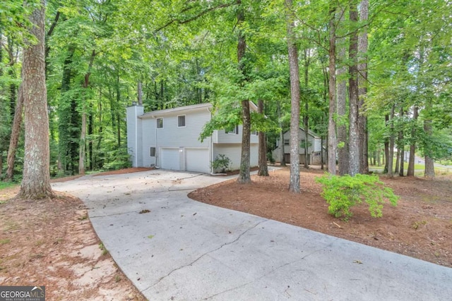 5215 Mainstreet Park Dr, Stone Mountain, GA 30088 - view of front facade featuring a garage, concrete driveway, and a chimney