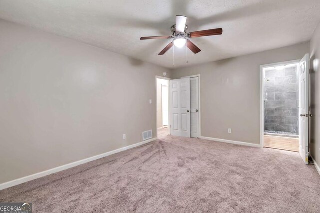 5215 Mainstreet Park Dr, Stone Mountain, GA 30088 - unfurnished bedroom with carpet flooring, connected bathroom, and a ceiling fan