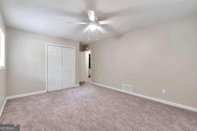 5215 Mainstreet Park Dr, Stone Mountain, GA 30088 - unfurnished bedroom featuring carpet, a closet, and a ceiling fan